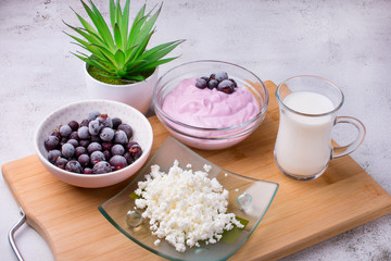 Fototapeta na wymiar Cottage cheese with fresh summer berries in a bowl, top view of the table. Healthy dairy product rich in calcium and protein homemade milk.