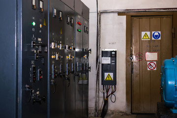 Outdated equipment control panel in an old production room. Long exposure. Low light. Glare, dust...