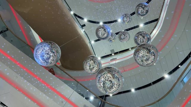 A lot of bright silver disco balls throw glare under the ceiling in the mall