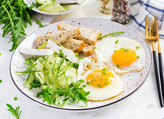 English breakfast - fried eggs, feta cheese, cucumber and arugula. American food.