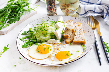 English breakfast - fried eggs, feta cheese, cucumber and arugula. American food.