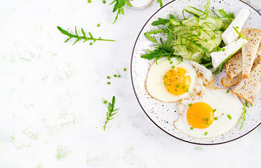 English breakfast - fried eggs, feta cheese, cucumber and arugula. American food. Top view, overhead, copy space