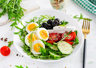 Breakfast. Greek salad and boiled eggs.  Fresh vegetable salad with tomato,  cucumbers, olives, arugula and feta cheese. Trend food.