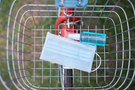 Self-defense Before Leaving The House, Mask And Alcohol Spray In  Bicycle Basket, Top View.