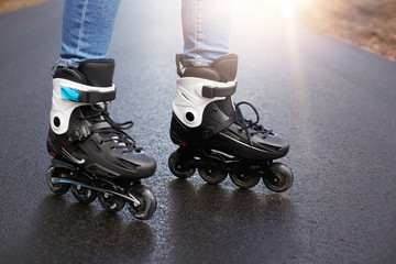 Outdoor picture of roller blades, being testified by unknown person, being in middle of road, tool...