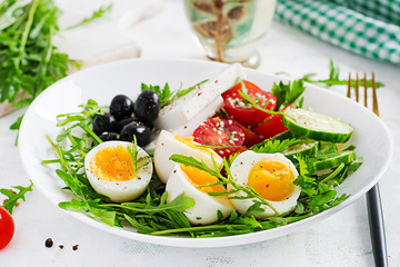 Breakfast. Greek salad and boiled eggs.  Fresh vegetable salad with tomato,  cucumbers, olives, arugula and feta cheese. Trend food.