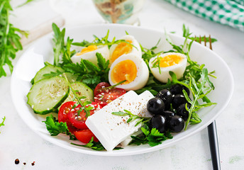 Breakfast. Greek salad and boiled eggs.  Fresh vegetable salad with tomato,  cucumbers, olives, arugula and feta cheese. Trend food.
