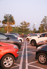 Image of cars parking in the opposite side in outdoor parking with natural background in twilight evening. Vertical view.
