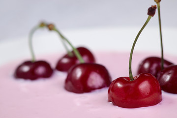Red cherry in yogurt close-up, healthy breakfast and good morning mood