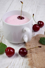 White cup with yogurt, cherries and mint. A wonderful breakfast and a great start to the day, healthy nutrition for weight loss and skin improvement