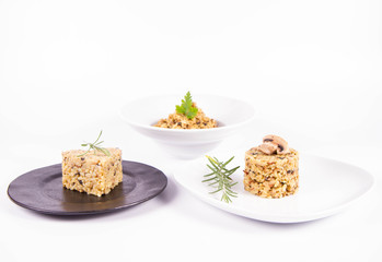 Risotto with button mushroom and bacon - three portions on different plates, on a white background