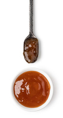 Small glass bowl and spoon of apricot jam