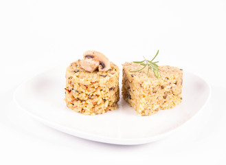 Risotto with button mushroom and bacon - two portions of different shape, on a plate on a white background