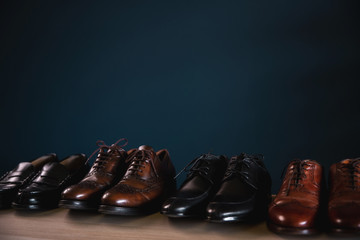 Men Footwear Fashion. Variety of Male’s Shoes on Shelf in House. Formal Leather Shoes, included Wingtip, Loafer and Oxford