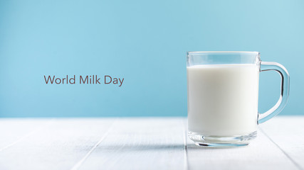  Banner. Mug of milk on a blue background. Lettering Milk Day. June 1st. Copy space.