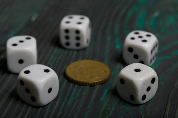Dice in white with black dots and a coin. On brushed pine boards.
