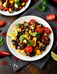 Avocado, mango salad with black bean on white plate