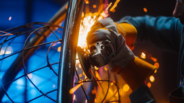 Close Up of a Talented Innovative Artist Using an Angle Grinder to Make an Abstract, Brutal and Expressive Metal Sculpture in a Workshop. Contemporary Fabricator Creating Modern Steel Art.