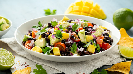 Avocado, mango salad with black bean, tomato, red onion and tortilla chips. healthy food