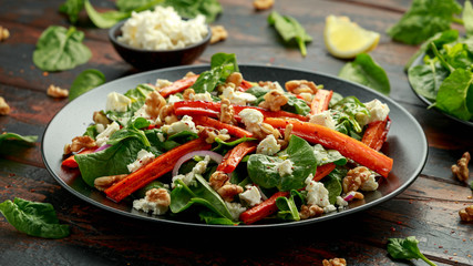Roasted carrot salad with feta cheese, walnut and spinach. healthy food
