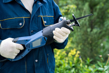 male hand with a reciprocating saber saw. construction work. 