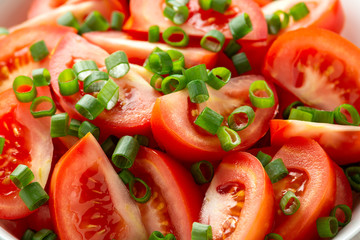 Tomato salad with spring onion and herbs in white bowl. Healthy summer food