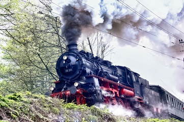 Historic train with steam lok, heavy smoke from the chimney