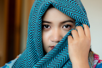 A beautiful Asian woman is wearing a face veil.