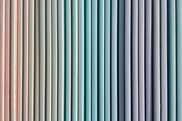 Colorful multi colored panels with a paper surface. Drywall panels are installed vertically. Multicolored striped texture background.