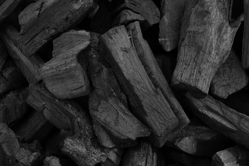 Natural fire ashes with dark grey black coals texture. It is a flammable black hard rock.  Space...