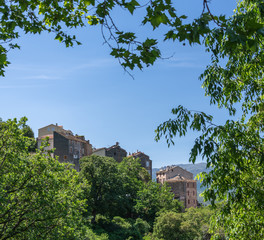 Traveling through the hills of Corsica. Trees framing a village. 