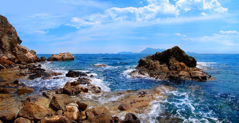 Panoramic landscape of the rocky seashore, sea waves, summer day