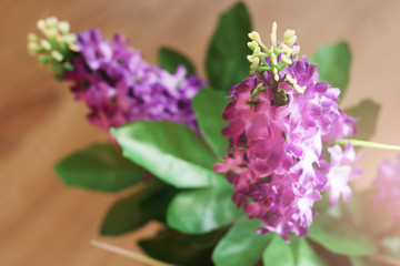 Obraz premium Bouquet of artificial lilac in a vase
