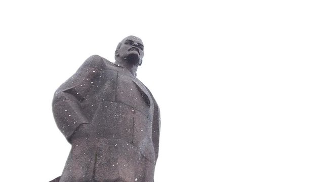 a statue of Lenin during a snowfall in slow motion