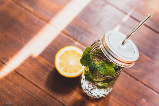 Fresh drink whith lemon and minton wooden background., refreshment