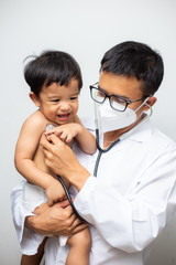 happy asian male doctor examining baby boy with stethoscope exam