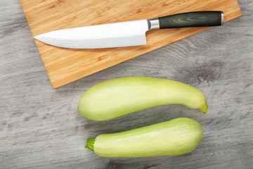 Fresh zucchini on wooden table Vegan food preparation concept. Flat lay view.