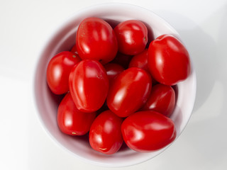 Cherry tomatoes in a bowl on white background