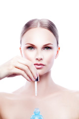 Naklejka premium Beauty model woman portrait with droplet of cosmetics cream hyaluronic bottle in hand