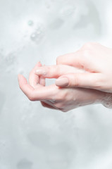 woman washes her hands over water with foam