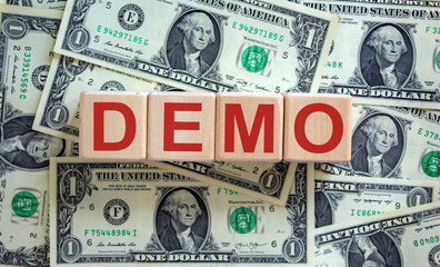 Concept word 'demo' on cubes on a beautiful background from dollar bills.