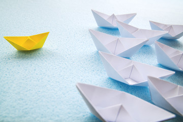 One yellow paper boat against dozens of large white ones. - 352233606
