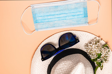 Medical mask, summer hat, sunglasses, bird cherry, flowers on a spring background. flat...