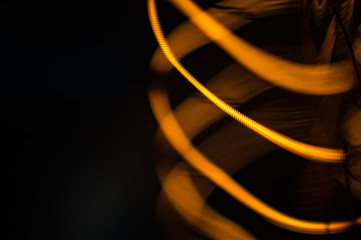 Glowing twisted spirals of edison lamp on black background, macro shot 