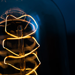 Macro shot of glowing swirl in edison lamp on dark background