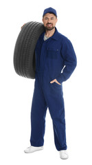 Fototapeta premium Full length portrait of professional auto mechanic with tire on white background