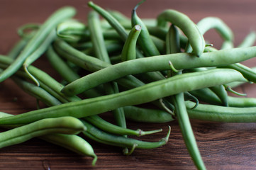 Bunch of green beans on a brown wooden floor
