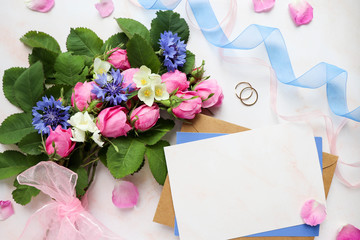 mock wedding card. bouquet of pink roses and a wedding ring on a white background. congratulation. wedding invitation