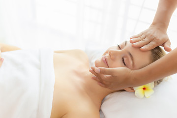 Obraz na płótnie Canvas Beauty woman having massage on face, head on spa bed at spa salon with smile face. Massage therapist massage customer face, rejuvenating look younger facial skin. spa treatment. Comfortable copy space