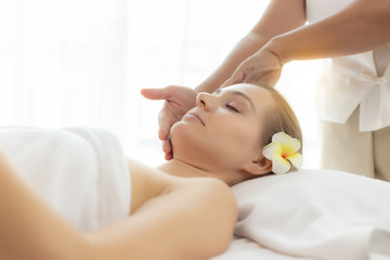 Fototapeta na wymiar Beauty woman having massage, scrub on face in spa bed at spa salon. Oriental massage therapist massage and scrub customer face, rejuvenating look younger facial skin. spa treatment with comfortable